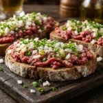Carne de Onça Curitiba: Receita e Cuidados Essenciais Carne de Onça Curitiba tradicional com carne bovina crua, cebola e cebolinha sobre broa de centeio.