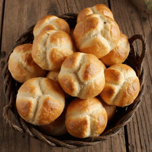 Cesta com pães de queijo mineiro dourados e recém-assados, com textura crocante por fora e macia por dentro, sobre uma mesa rústica de madeira.