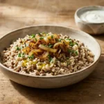 Mujaddara do Levante: Arroz com Lentilha Árabe Simples Arroz com lentilha árabe mujaddara servido com cebola caramelizada, iogurte, salada fresca e pão sírio.